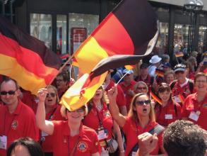 Fahnen schwenkende Lionsmitglieder bei der Internationalen Parade einer Lions-Convention.