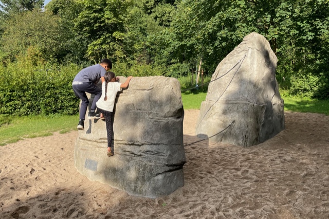 Zwei Kinder erklimmen den Kletterfelsen