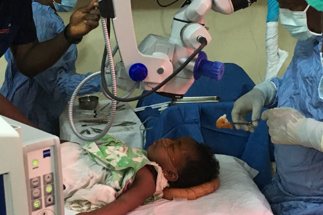 Ein kleines Mädchen in Sierra Leone liegt auf einem OP-Tisch und wird am Auge operiert – Foto 1