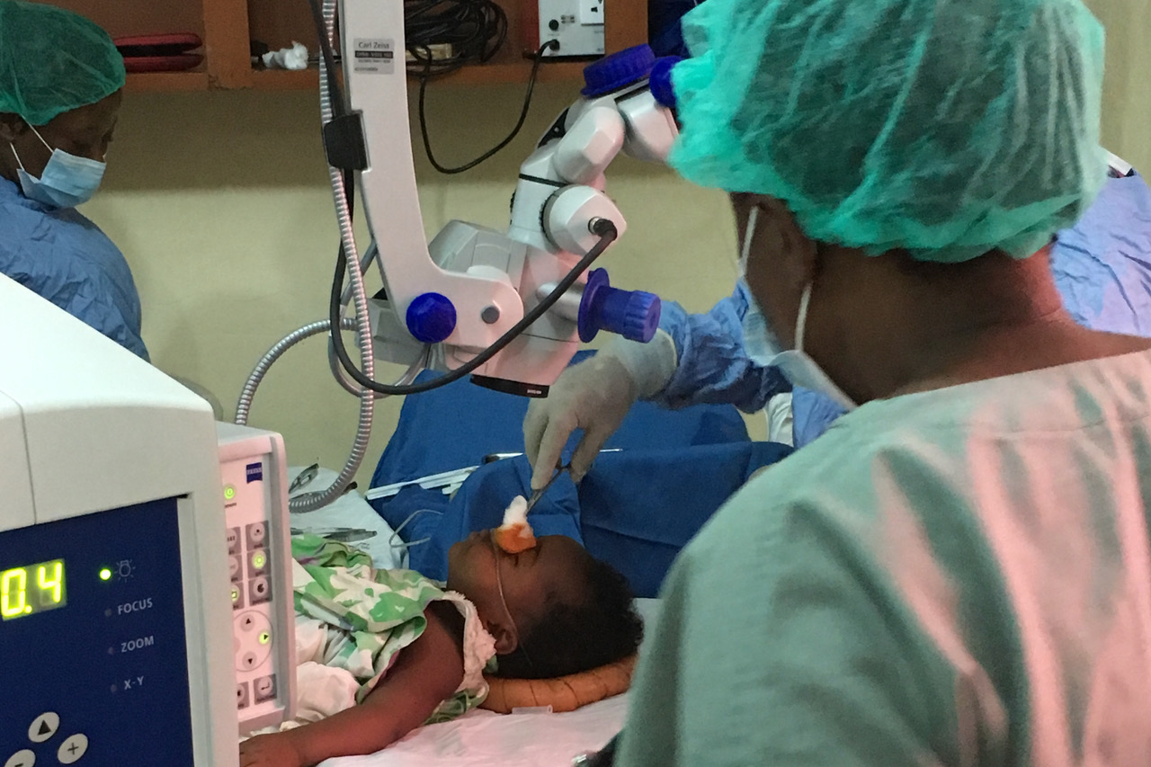Ein kleines Mädchen in Sierra Leone liegt auf einem OP-Tisch und wird am Auge operiert – Foto 2