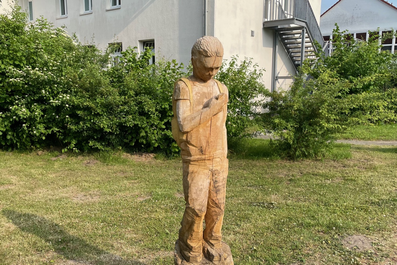 Holzskulptur Schüler mit Handy