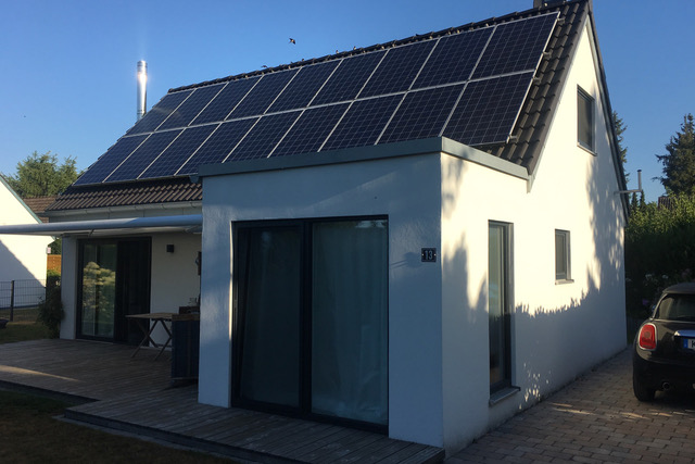 weißes alleinstehendes Einfamilienhaus mit Photovoltaikanlage