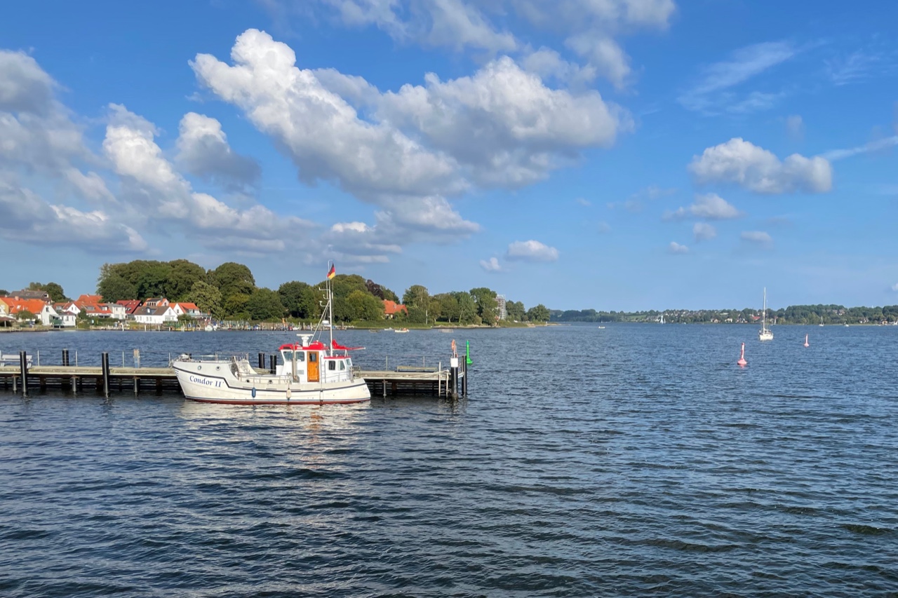 Blick von Stadthafen zur großen Breite, linker Hand der Holm, im Vordergrund liegt ein Fischerboot am Steg