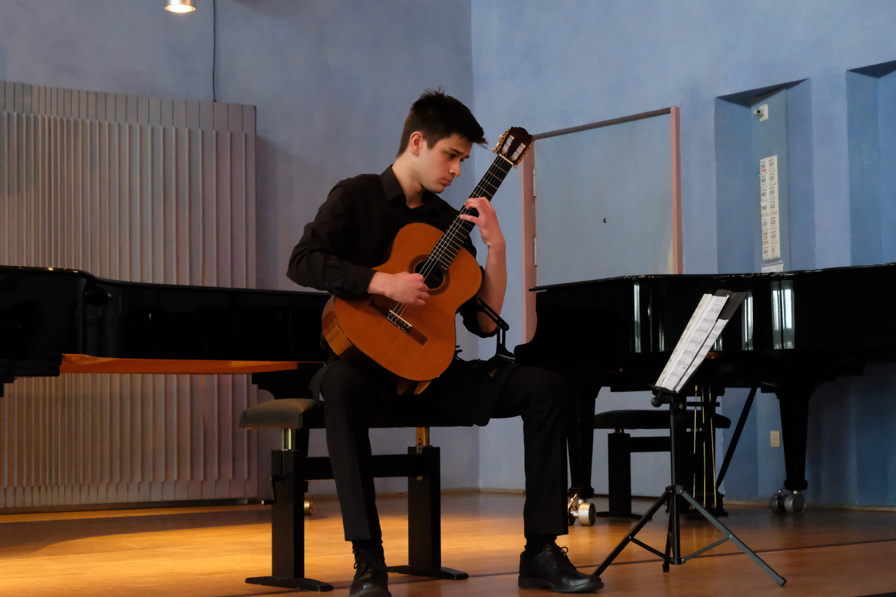 Ein junger Mann spielt beim Wettbewerb Klassische Gitarre