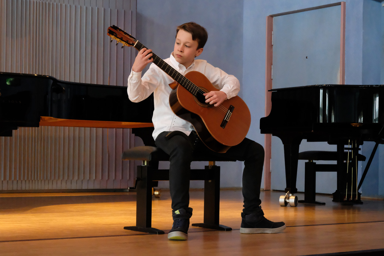 Ein anderer junger Mann spielt beim Wettbewerb Klassische Gitarre