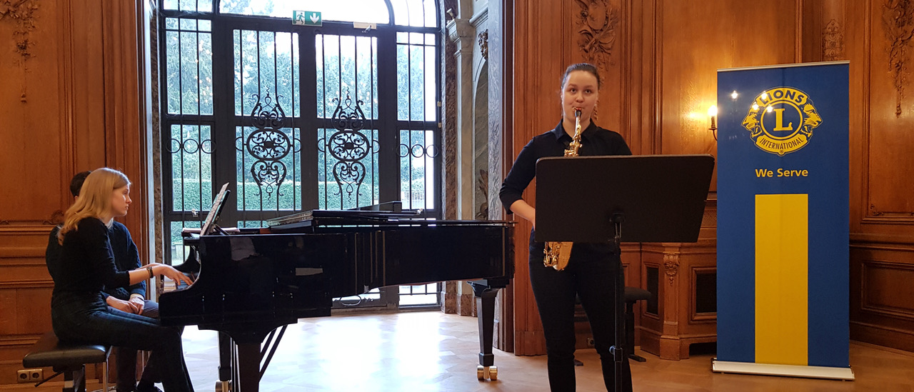 Eine junge Frau spielt beim Wettbewerb für Saxophone vor. Sie wird durch jemanden am Flügel begleitet.