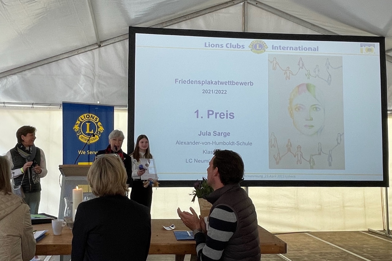 Jula Sarge wird der 1. Preis für ihr Siegerplakat überreicht