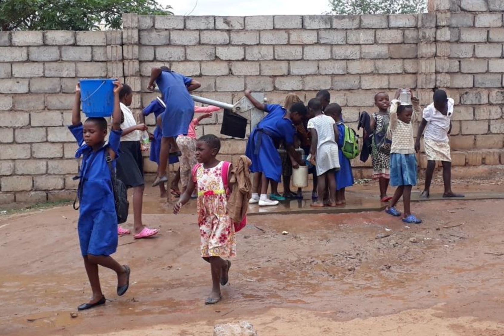 Schulkinder holen Wasser an einem neu gebohrten Brunnen