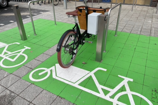 grüne Pflasterfläche mit Piktogramm eines Lastenrads zeigen den reservierten Parkraum